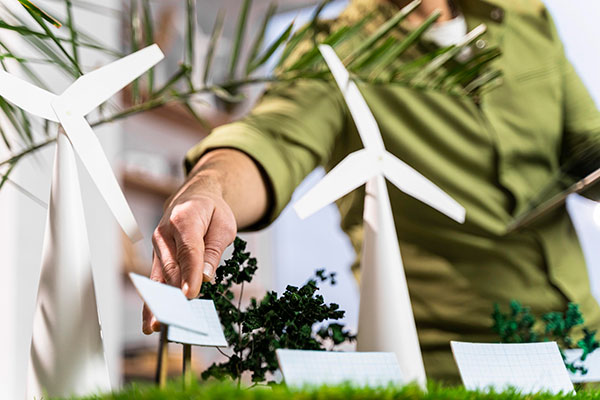 Imagen de un hombre arreglando el diseño sobre una maqueta de un parque de energía renovable.